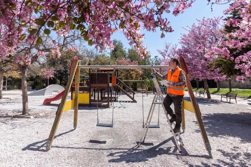 Ein Prüfer untersucht Spielgeräte auf einem Spielplatz